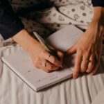 woman writing on note book journaling